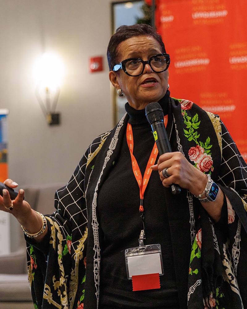 A speaker addresses the room with a microphone during a signature session at a past Ascension gathering.